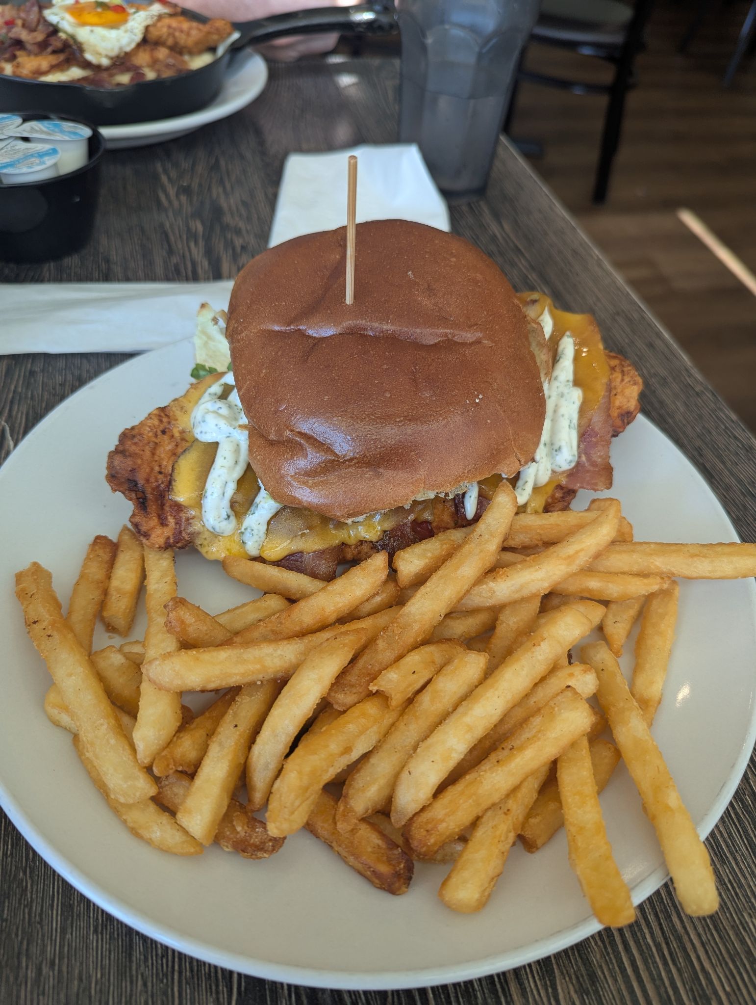 A fried chicken sandwich club with guacamole. 