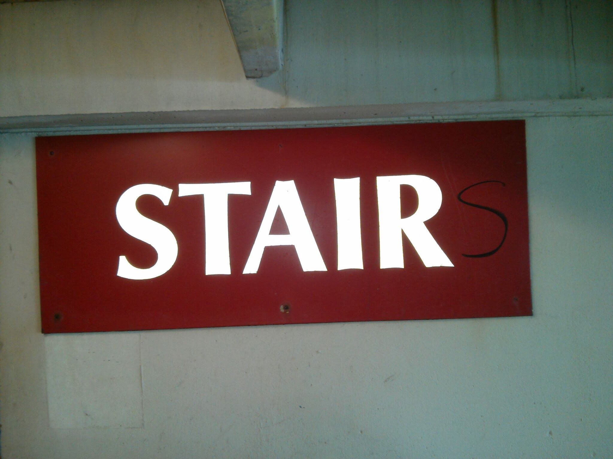 A sign that says, "STAIR" with the letter "S" tacked on at the end in marker.